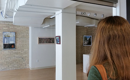 A woman looks at artwork in the show